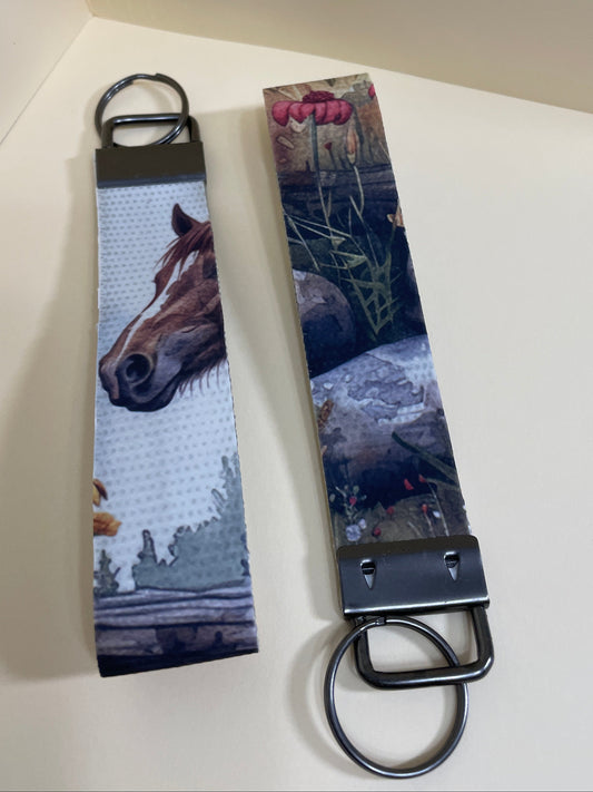 Two keychains with nature-themed designs on a light surface
